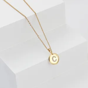 Gold stainless steel chain necklace detail, sparkling crystal letter C pendant.