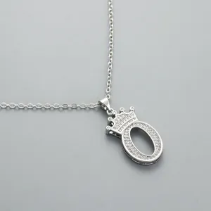 Close-up of a silver crown letter O pendant necklace with sparkling pavé stones detail.