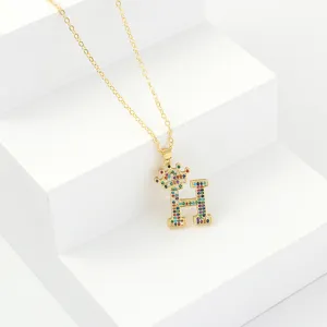 Gold color rhinestone crown letter H necklace detail view showing sparkling colorful crystal paved finish.