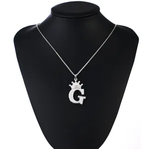 Detail view of the silver letter G crown pendant featuring sparkling zirconia stones.