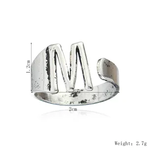 Détail de la bague ouverte lettre M argentée vintage, bague en cuivre rétro ajustable.