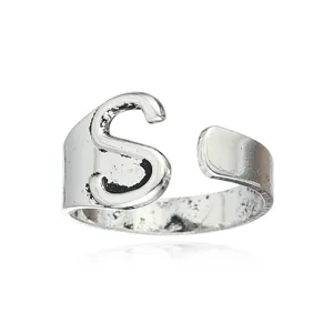 Bague ouverte ajustable avec lettre S en argent vintage, detail de bijou mode minimaliste.