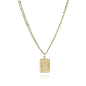 Gold tone curb chain necklace featuring a rectangular pendant with letter F detail close up view