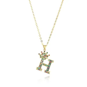 Gold-plated letter H pendant necklace detail with colorful sparkling cubic zirconia and crown.
