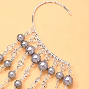 Detail shot of multi-layer pearl ear cuff, elegant silver-tone hanging jewelry accessory.