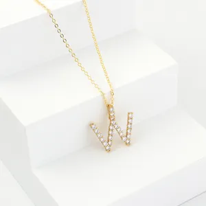 Detailed shot of the gold-plated chain necklace featuring a dazzling paved letter W pendant.