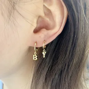 Gold letter huggie earrings with diamond pendant detail, stylish alphabet jewelry for women.