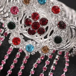 Dettaglio ravvicinato del bracciale da braccio con nappe in strass argentati e cristalli.