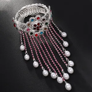 Dettaglio in primo piano del bracciale da braccio in strass con nappa di perle, festa.