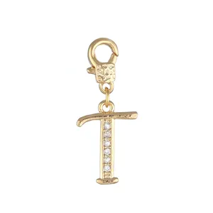 Gedetailleerde close-up van een gouden letter T bedel hanger versierd met sprankelende zirkonia stenen.