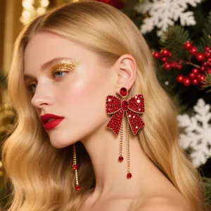 Magnifiques boucles d'oreilles nœud de Noël en strass rouges avec de élégantes chaînes dorées.