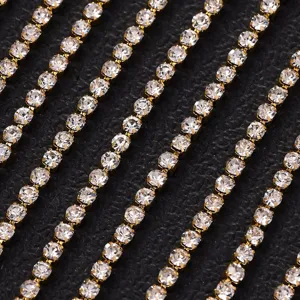 Dettaglio catena di strass con cristalli trasparenti in montature ad artiglio dorato.