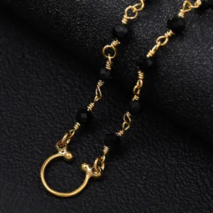 Detailed view of gold facial chain with black beads, exquisite festival party accessory.