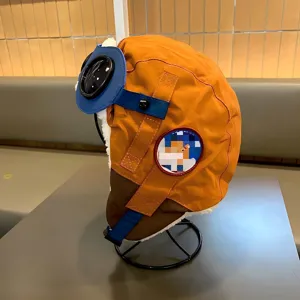 Kinder Pilotenmütze Detailansicht, orangefarbene Wintermütze mit Fellfutter und Brille.