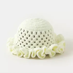 Detailed close-up of handmade crochet hollow bucket hat with lovely ruffled brim design.