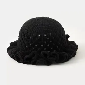 Black crochet hollow-out knit hat detail with delicate ruffled brim and breathable texture.