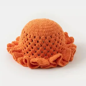 Detailed view of orange handmade crochet bucket hat with hollow-out design and cute ruffles.