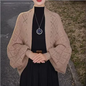 Detail shot of women's beige knit cardigan, diamond hollow open front shawl with lantern sleeves.