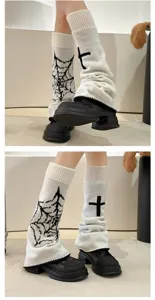Detailed close-up view of knitted leg warmers featuring gothic cross and spiderweb patterns.