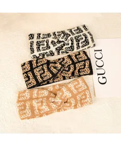 Bandeau en tricot noué avec motif monogramme classique, accessoire de cheveux élégant.