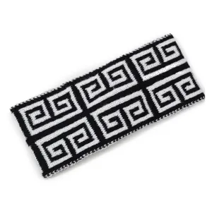 Black and white knit headband with geometric Greek key pattern, stylish hair accessory.