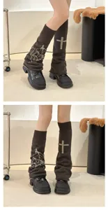 Detailed view of dark brown knitted leg warmers with cross pattern and gothic style.