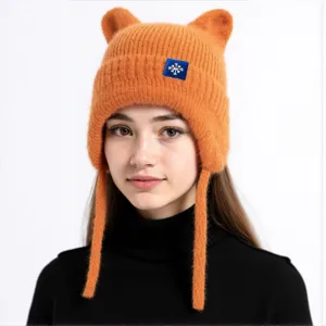 Detailansicht der orangefarbenen gestrickten Ohrenklappenmütze mit niedlichen Ohren für Winter.