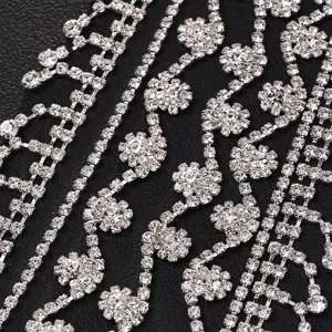 Primer plano de cadenas de pedrería brillante para el cabello y accesorios con borlas florales.
