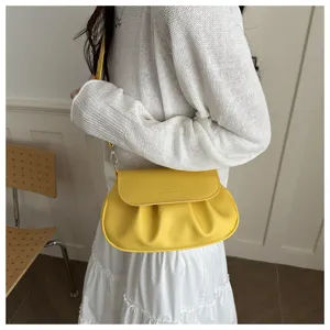 Detail shot of the trendy yellow gathered flap saddle bag, highlighting texture.