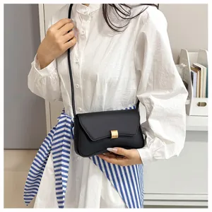 Dettagli della borsa a tracolla nera elegante con cinturino annodato indossata da una modella.