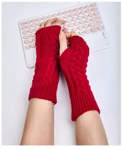 Details of red cable knit fingerless gloves and arm warmers, cozy winter hand protection.