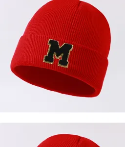Close up view of the red winter knit beanie hat featuring a bold black letter M patch.