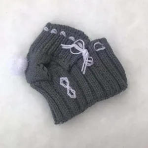 Grey knitted pet hat with cute white pom pom and lace up design for small dogs winter warmth.
