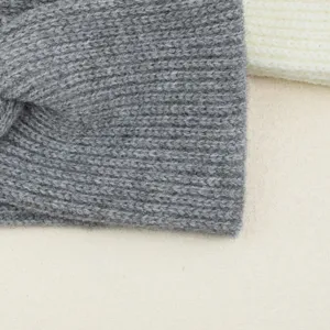 Vue détaillée du élégant bandeau torsadé en tricot gris, accessoire pour cheveux.