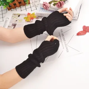Detailed view of black knitted arm warmers, showing ribbed texture and fingerless design.