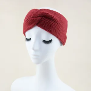 Vue détaillée du bandeau tricoté rouge, montrant sa texture douce et son design chaleureux.