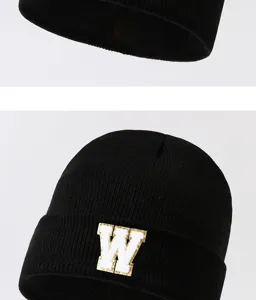 Black knitted beanie hat detail, cozy warm winter skull cap featuring a white letter W patch.
