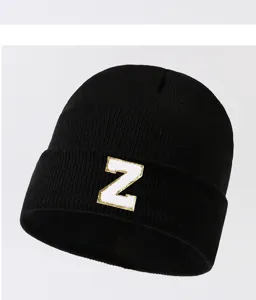 Detail view of black knit beanie with white gold letter Z patch winter warm fashion hat