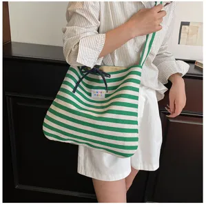 Detail shot of green striped canvas tote bag showing shoulder strap and casual daily style.