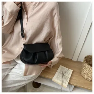 Black pleated flap saddle bag detail showing texture and chic shoulder strap design for commute.