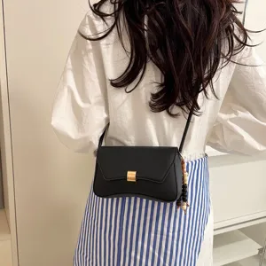Borsa a tracolla nera chic con chiusura dorata e ciondolo di perle per ogni giorno.