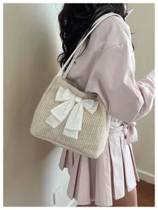 Detail view of the woven straw shoulder bag with elegant white bow, fashionable daily wear.