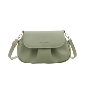 Green pleated flap saddle bag for women, elegant crossbody purse with gold hardware.