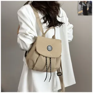 Vue détaillée d'un sac à dos en tissu kaki décontracté avec cordon et badge sportif.