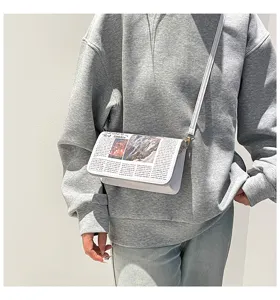 Sac bandoulière tendance avec imprimé journal pour femmes, accessoire chic et élégant.