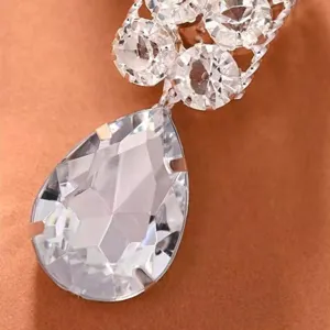 Gros plan détaillé de boucles d'oreilles strass en forme de goutte, facettes de cristal brillantes.