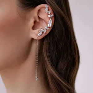 Detalle de impresionante pendiente de cristal con pedrería brillante y cadena fina.