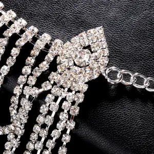 Primer plano del detalle de la cadena de pelo con flecos de pedrería brillante, joya plateada.