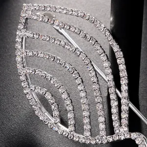 Close-up detail of rhinestone leaf glasses frame, sparkling crystal metallic eyewear decor.