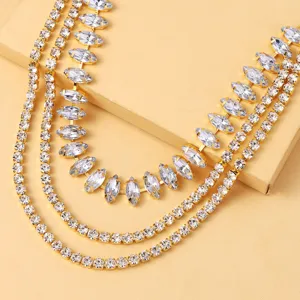 Gros plan du collier ras du cou en strass multicouche, cristaux brillants sur chaîne dorée.